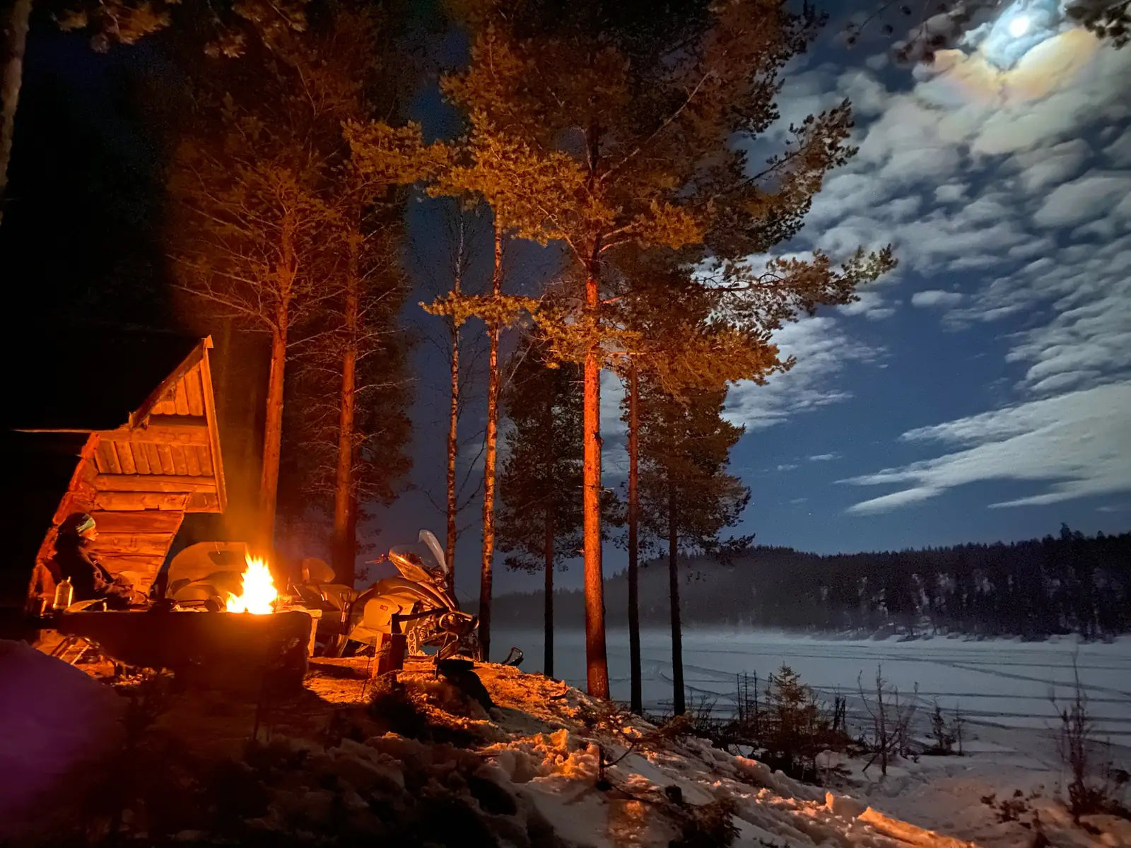 Snowmobile camp by the frozen lake